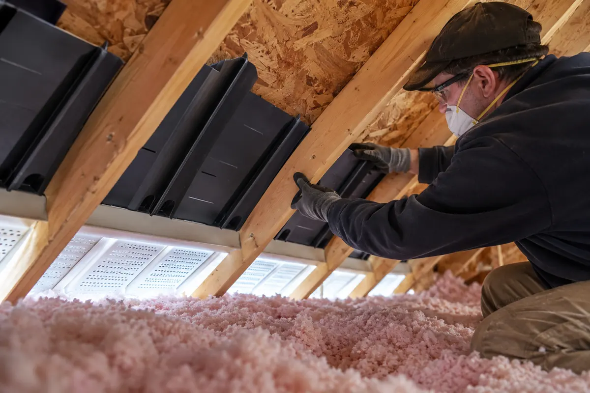 Technician working at attic ventilation baffle